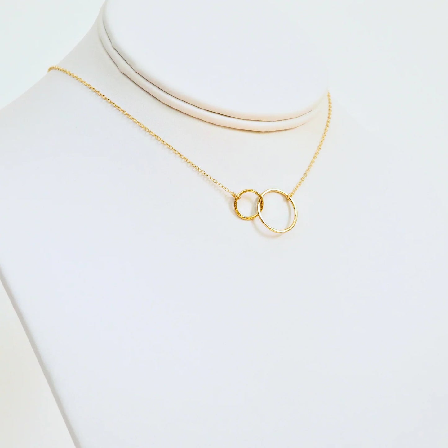 Gold necklace with a unique pendant on a white background