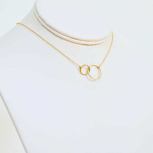 Gold necklace with a unique pendant on a white background