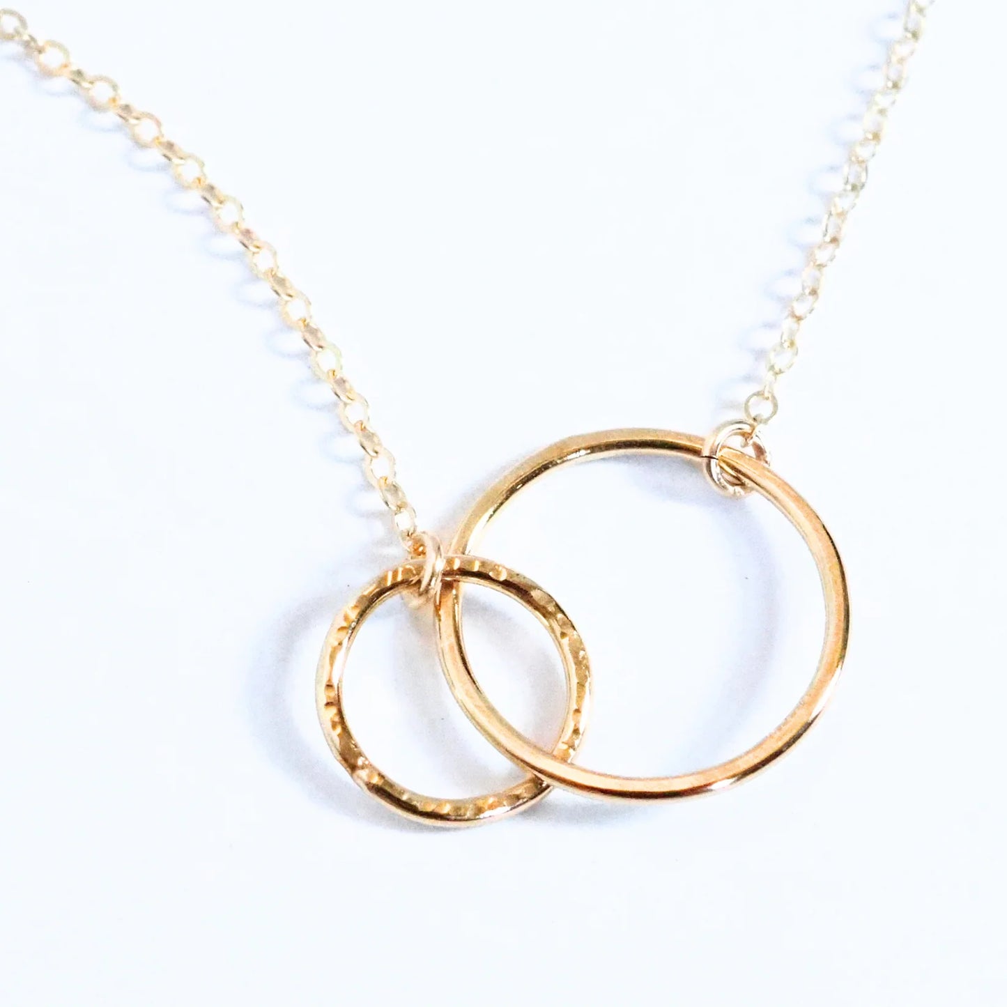 Gold necklace with interlocking rings on a white background