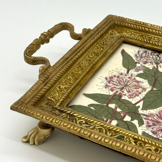Decorative brass tray with floral design on a white background