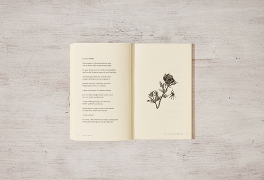 Open book with a floral illustration on a wooden surface