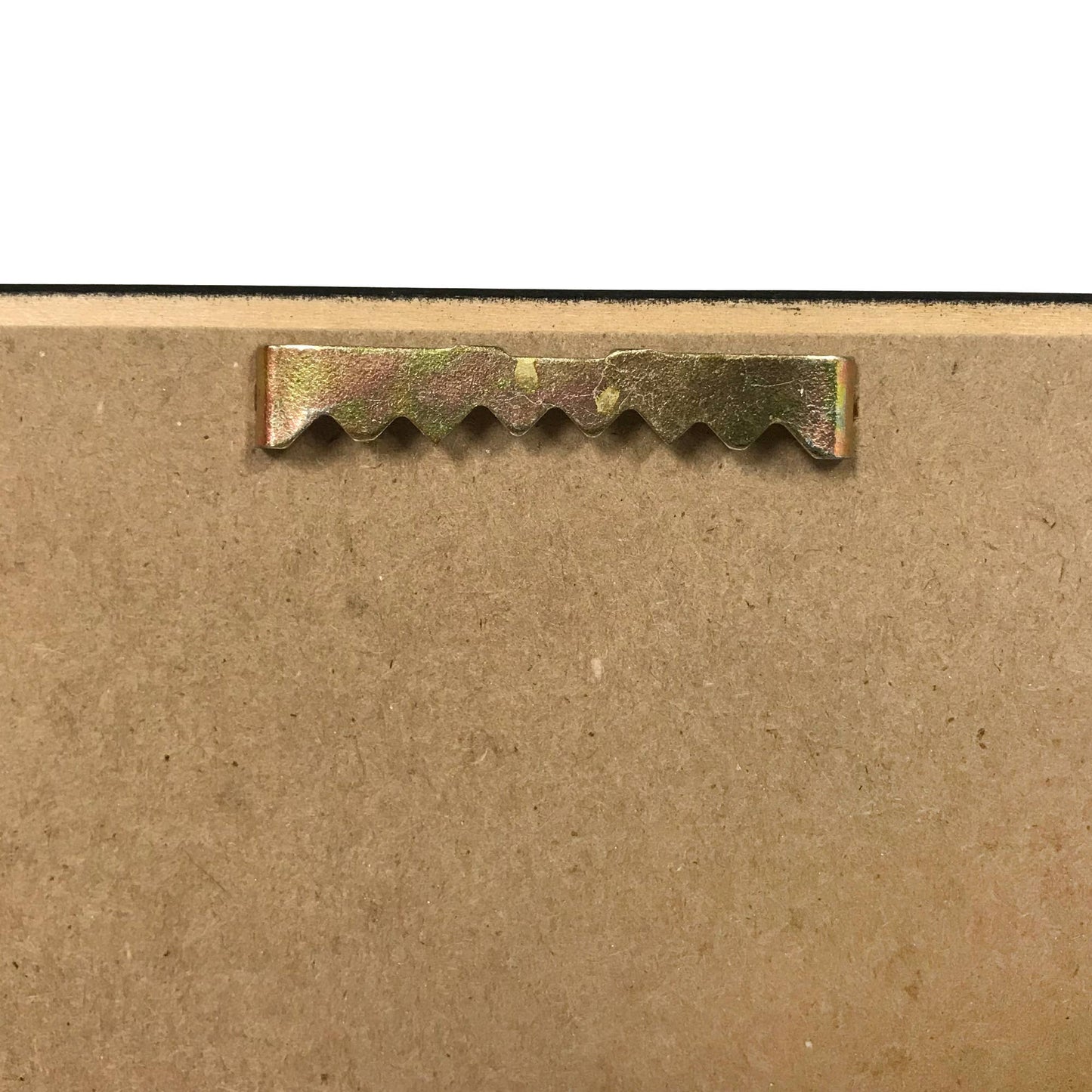 Close-up of a metal strip with teeth on a cardboard background