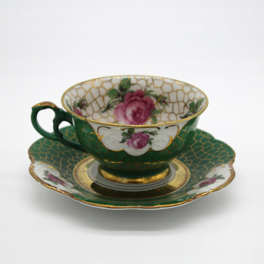 Decorative ceramic teacup and saucer with floral patterns on a white background