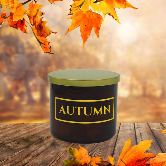 Black container with 'AUTUMN' label on a wooden surface with autumn leaves.