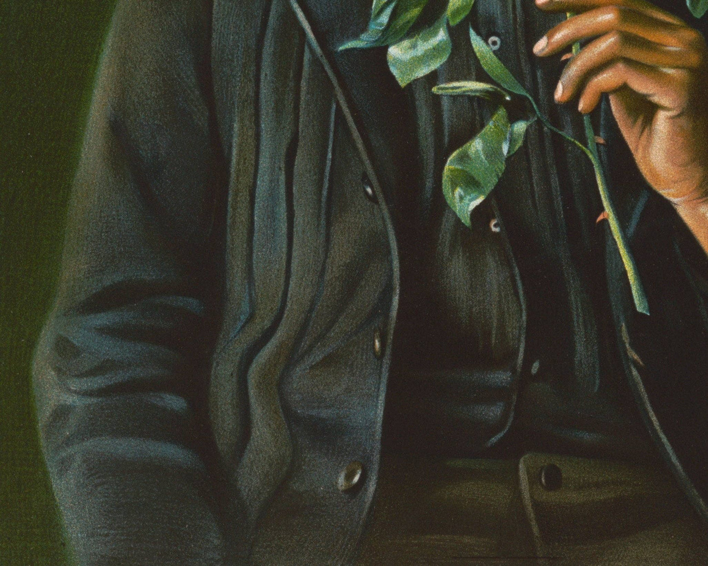 Person wearing a dark coat holding green leaves against a dark background