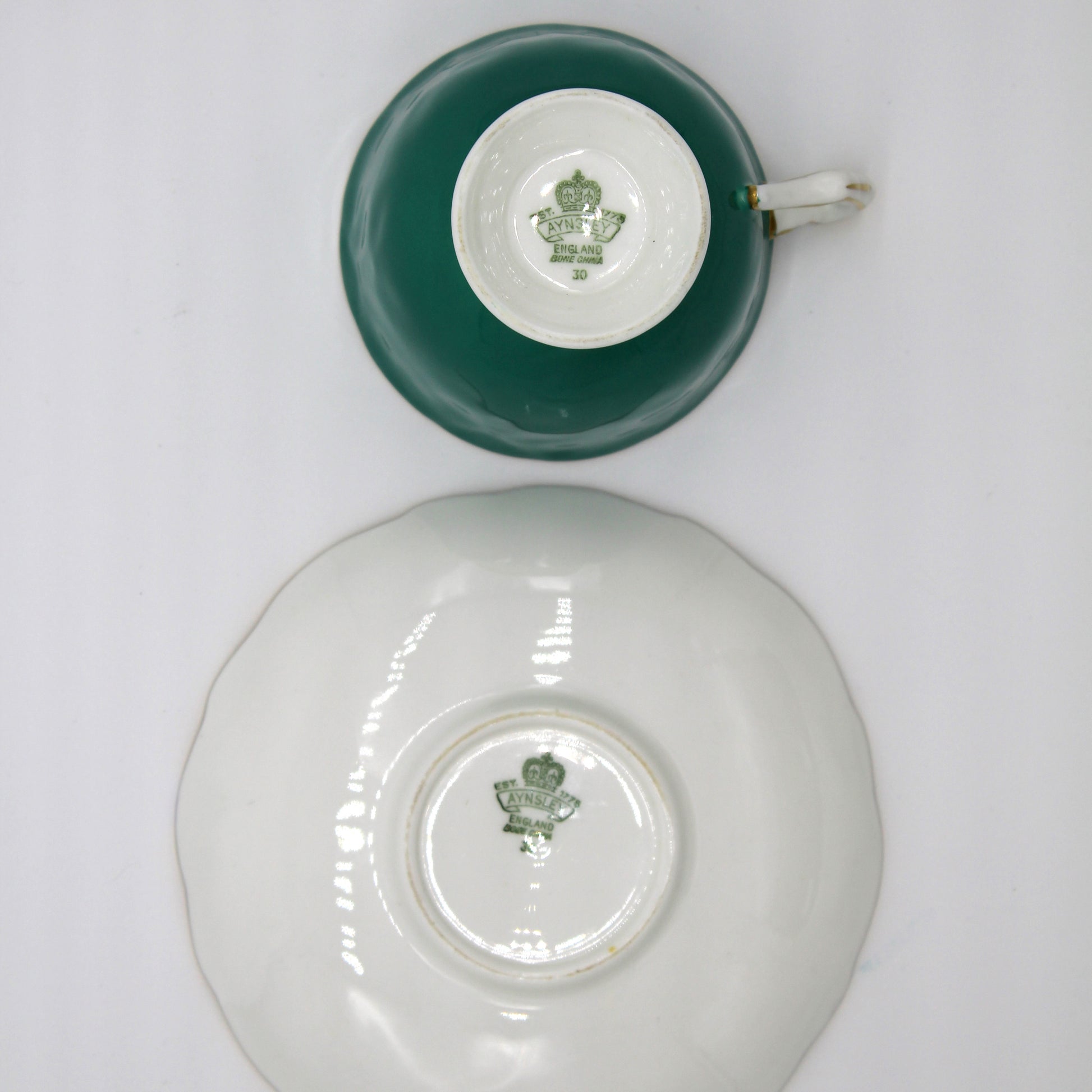 Teal and white cup and saucer set on a white background