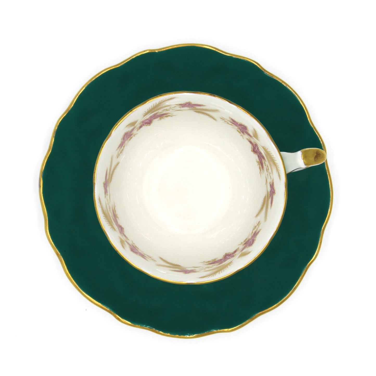 Teacup on teal saucer with gold accents on a white background
