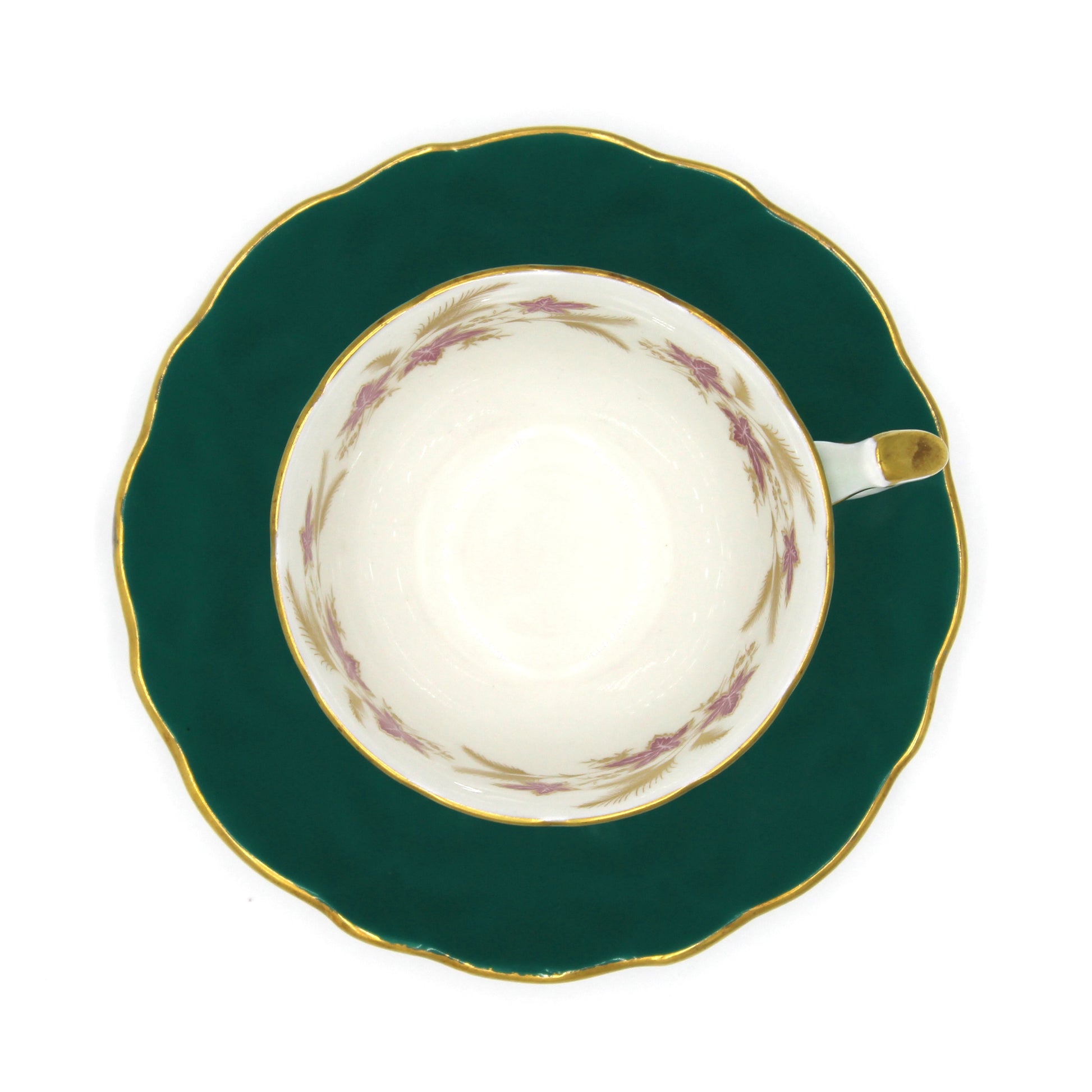 Teacup on teal saucer with gold accents on a white background