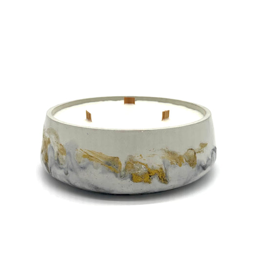 Concrete candle with black and gold accents on a white background
