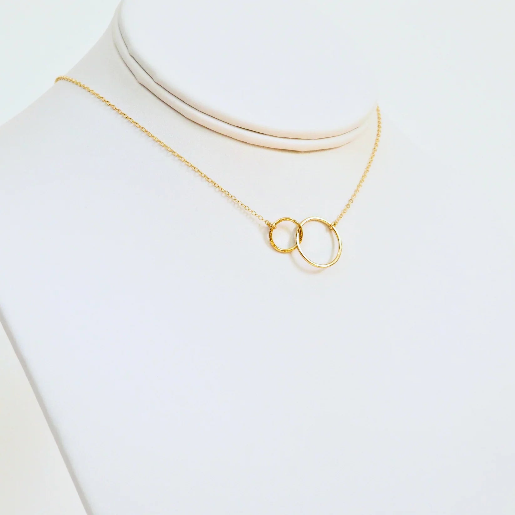 Gold necklace with a unique pendant on a white background
