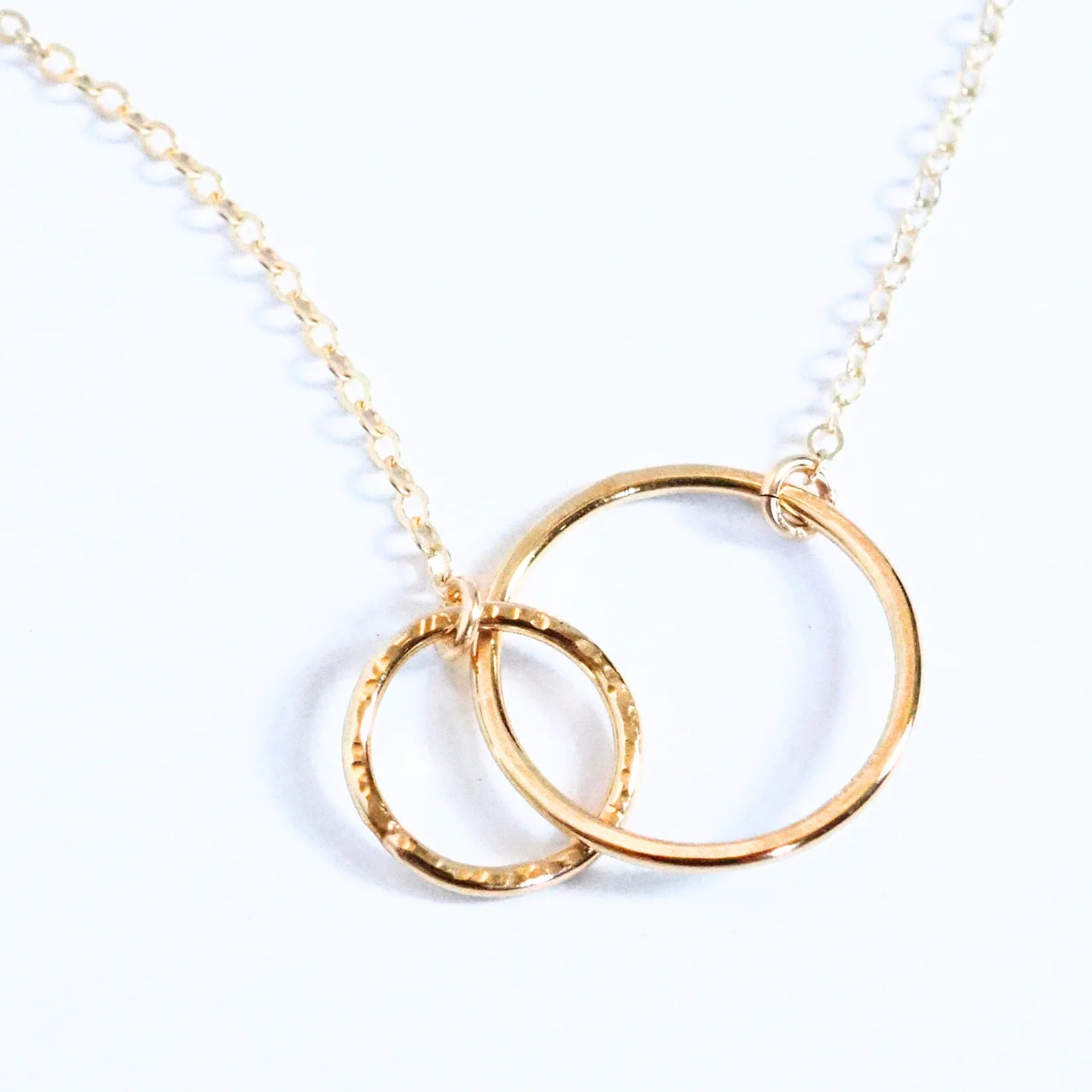 Gold necklace with interlocking rings on a white background