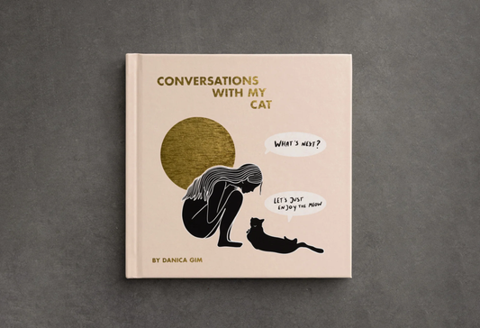 Book titled 'Conversations with My Cat' by Danica Om on a gray background