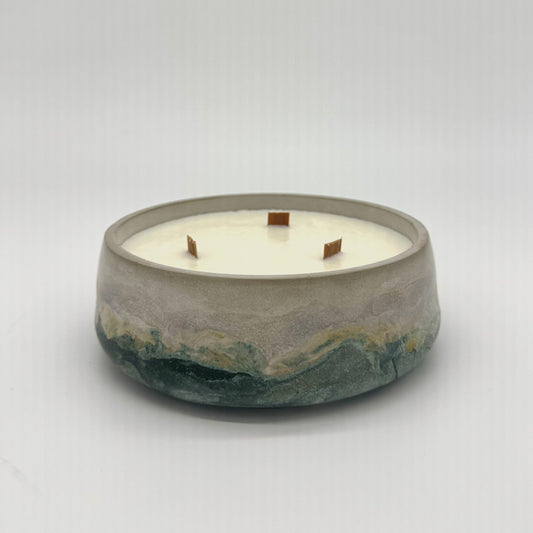 Concrete candle with a white candle and three wood wicks on a light gray background