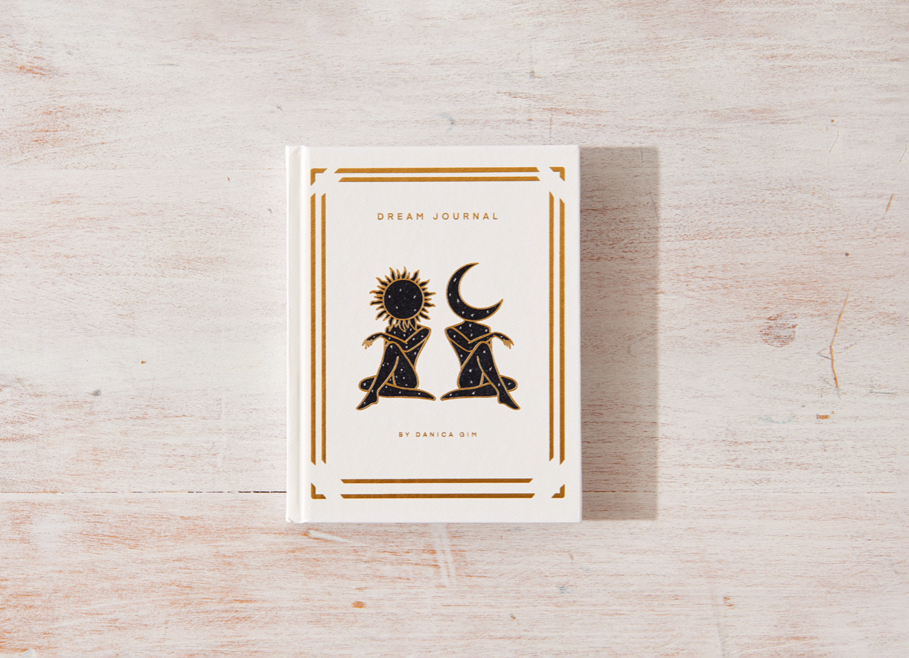 Dream journal with celestial design on a wooden surface
