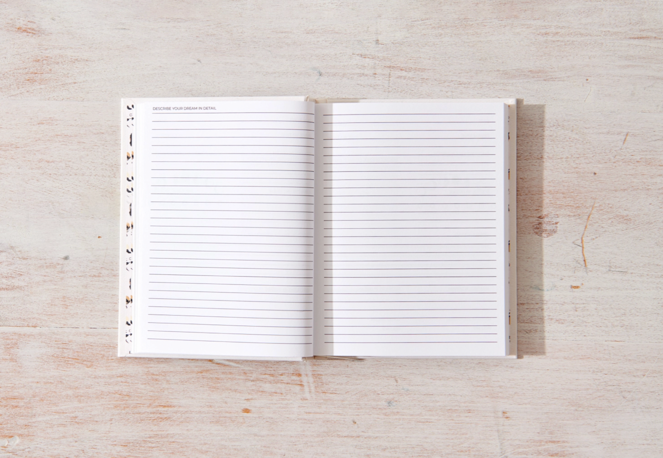 Open notebook with lined pages on a wooden surface