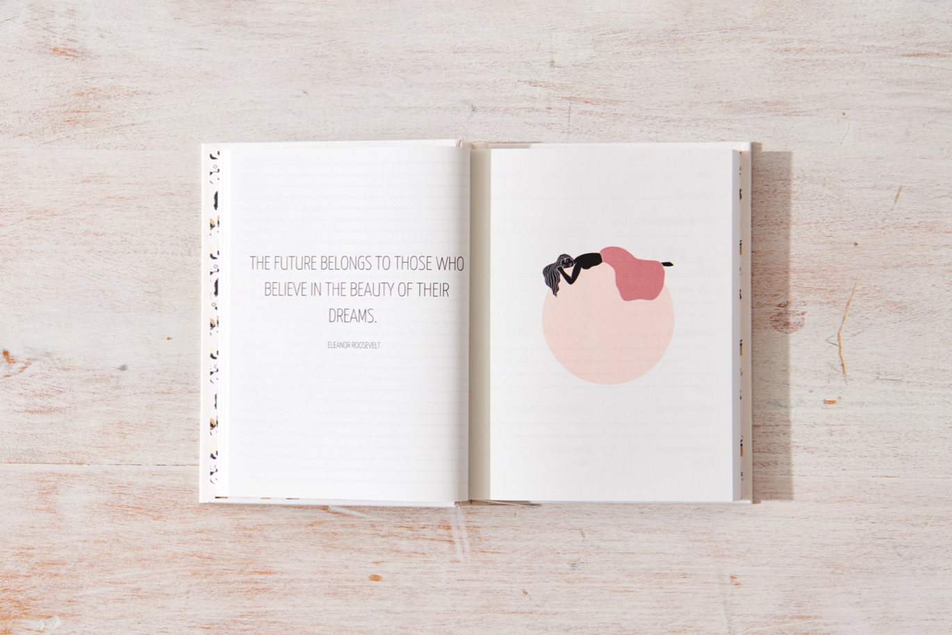 Open book with a quote and illustration on a wooden surface
