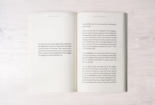 Open book with text on a light wooden surface