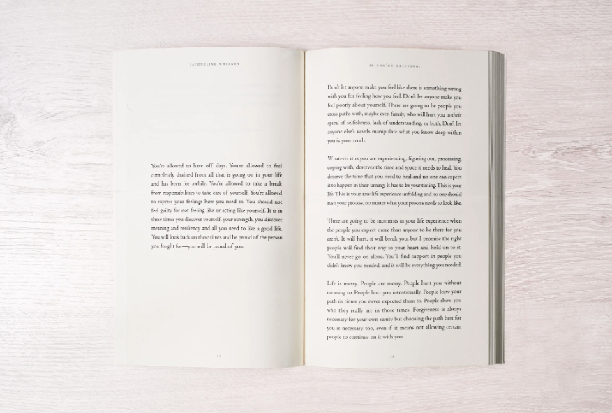 Open book with text on a light wooden surface