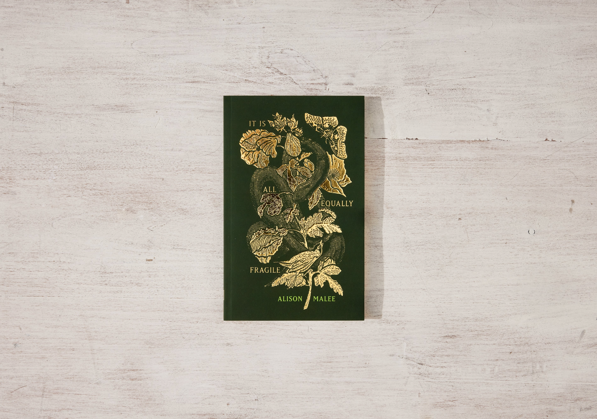 Book with floral design and text on a light wooden surface