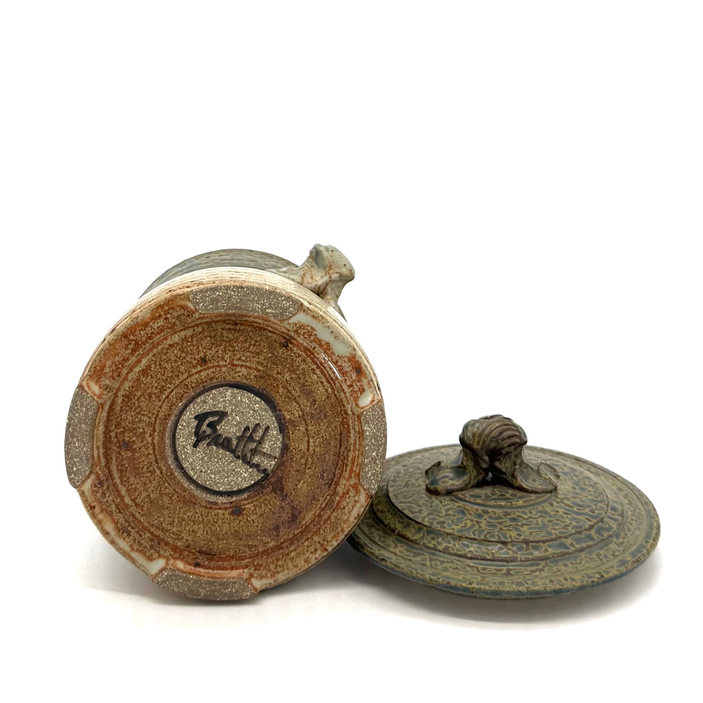 Bottom of pottery displaying signature with lid on a white background