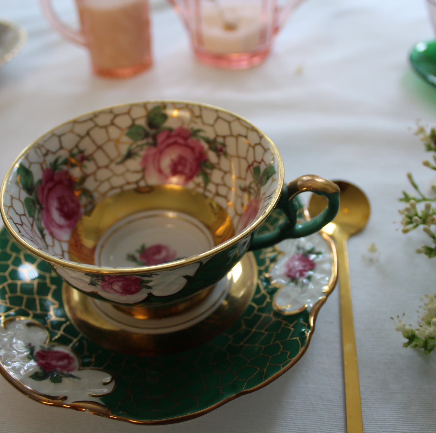 Decorative teacup with floral design on a white tablecloth.