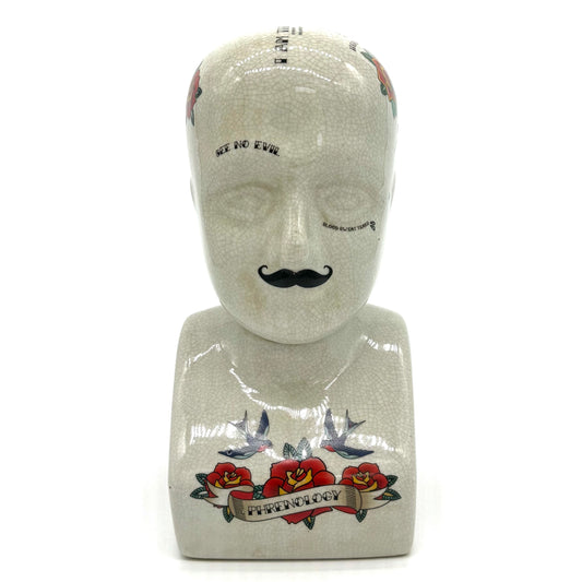 Mannequin head with tattoo designs on a white background