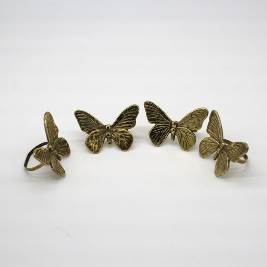 Four bronze butterfly-shaped rings on a white background